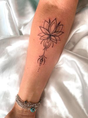 Experience the beauty of a lotus in stunning ornamental style with this exquisite tattoo designed by talented artist Gabriela.