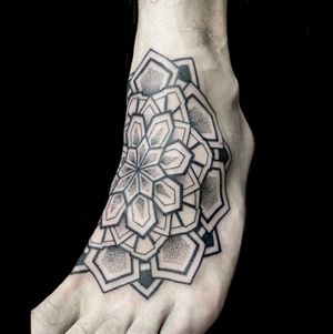 Get mesmerized by the detailed dotwork and ornamental patterns in this beautiful flower mandala tattoo by the talented artist Rose Harley.