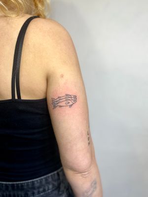 Get inked with a delicate hand-poked fish design by the talented Charlotte Pokes. Embrace the beauty of fine line art in this stunning tattoo.
