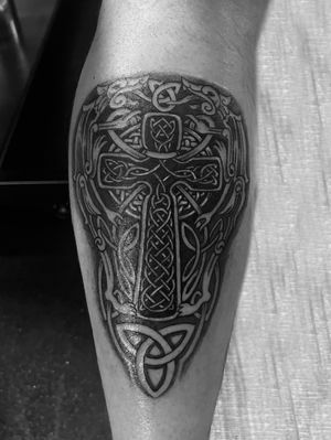 Beautiful black and gray illustrative tattoo by Gabriele Lacerenza, featuring a intricate celtic knot design intertwined with a cross symbol.