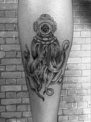 An illustrative tattoo featuring a majestic octopus interacting with a diver, expertly crafted by Gabriele Lacerenza.