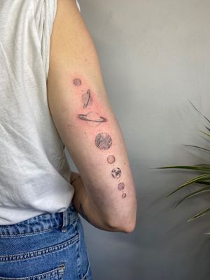 Experience the beauty of the solar system with intricate dotwork and fine lines in this illustrative tattoo by Charlotte Pokes.