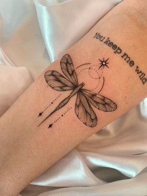 Capture the delicate beauty of a dragonfly with this exquisite illustrative tattoo by the talented artist Gabriela.