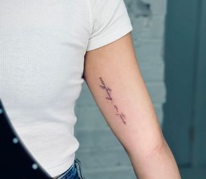 Elegant fine line tattoo with small lettering, expertly crafted by Tal for a timeless and subtle look.