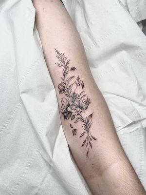 Elegant fine line tattoo featuring a beautiful floral motif with intricate branches, sprigs, and twigs. Perfect for lovers of minimalist botanical designs.
