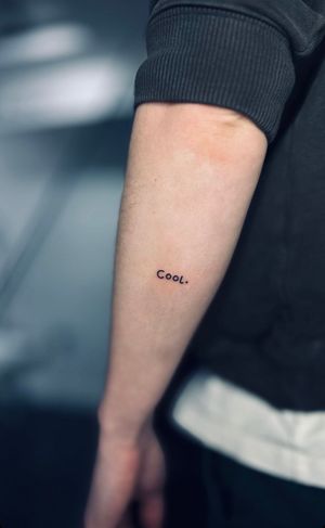 Get a chic and understated small lettering tattoo by Tal, perfect for a subtle yet stylish addition to your body art collection.