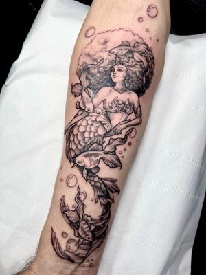 Unique dotwork style tattoo of a mermaid swimming with a fish, done by talented artist Beyza Taser.