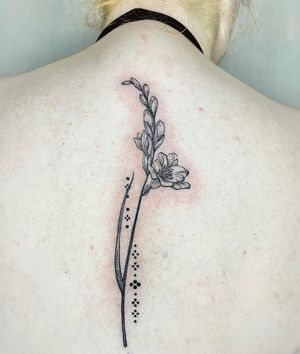 Beautifully detailed tattoo featuring a realistic flower and branch design, expertly done by the talented artist Beyza Taser.