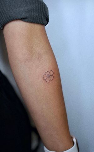 Elegantly detailed fine line tattoo of a delicate flower, expertly crafted by Tal. Perfect for those who appreciate intricate botanical designs.