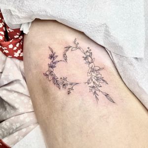 Elegantly designed by Beyza Taser, this tattoo combines intricate fine line details and beautiful motifs of flowers and hearts for a stunning and meaningful piece of body art.