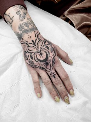 Beautiful blackwork tattoo designed by Beyza Taser, featuring intricate ornamental details on a delicate hand motif.