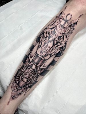 Illustrative tattoo featuring Anubis and scarab motifs, expertly done in blackwork style by Beyza Taser.