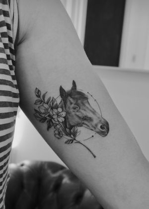 Experience the beauty of realism and illustrative style with this black_and_gray tattoo by Math, showcasing a stunning horse and intricate flower design.