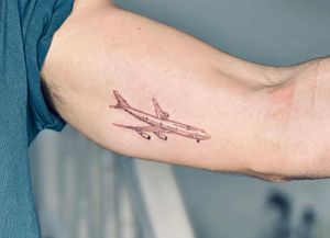 Experience the thrill of travel with this fine line tattoo featuring a 747 airplane, created by the talented artist Tal.