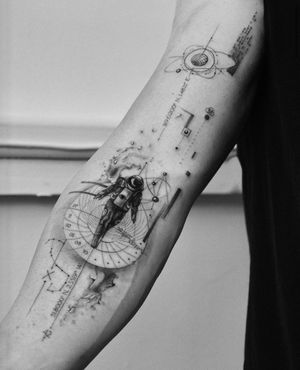 Explore the cosmos with this intricate black and gray, fine line tattoo by Victoria featuring a planet, astronaut, and coordinates. Perfect for space enthusiasts!