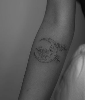 Capture the beauty of the night sky with this intricate fine line tattoo featuring a moon and cloud motif by talented artist Meg.
