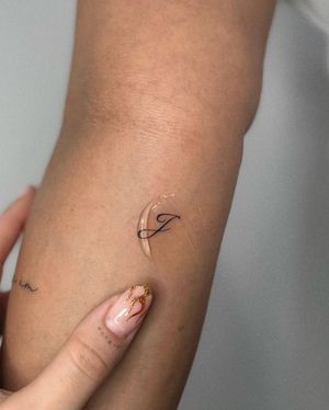 Elegantly crafted small lettering tattoo by Meg, perfect for minimalistic lovers seeking subtle sophistication.
