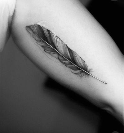 Explore the intricate beauty of this black and gray illustrative feather tattoo, expertly crafted by Victoria.