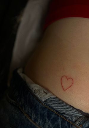 Elegant, minimalist fine line red heart tattoo by artist Meg, perfect for expressing love and passion.