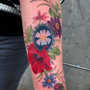 Beautiful full colour floral realism piece on the inner forearm.