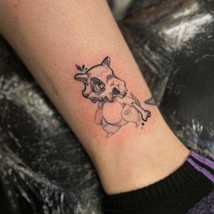 Get the cutest anime-inspired Cubone tattoo by the talented artist Holly Valley. Embrace your love for Pokemon with this unique illustrative design!