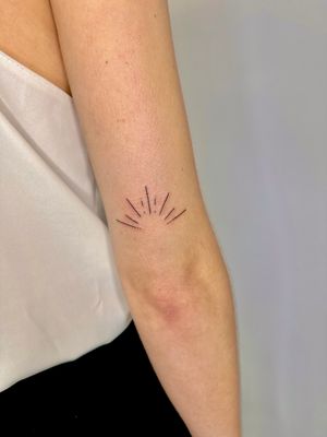 Beautiful and intricate fine line tattoo of a delicate sun by jadeshaw_tattoos. Perfect for those who appreciate subtle and intricate designs.