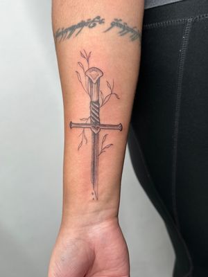 Get inspired by Lord of the Rings with this intricate illustrative tattoo featuring Narsil sword and vine details. By jadeshaw_tattoos.