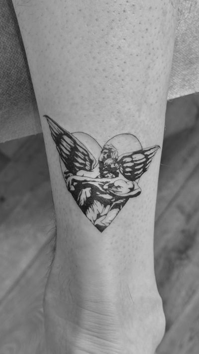 Beautiful blackwork tattoo combining a heart and angel motif, inspired by Cella Magnani and Rizzoli, created by Saka Tattoo.
