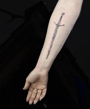 Embrace your inner warrior with this illustrative tattoo featuring a viking sword and powerful runes, expertly inked by the talented Rose Daniel.