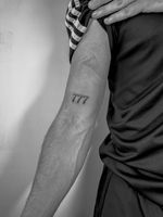 Get a minimalist and stylish number tattoo designed by the talented artist Oliver Soames. Perfect for a meaningful date or lucky number.
