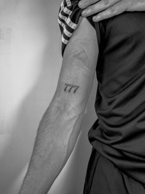 Get a minimalist and stylish number tattoo designed by the talented artist Oliver Soames. Perfect for a meaningful date or lucky number.