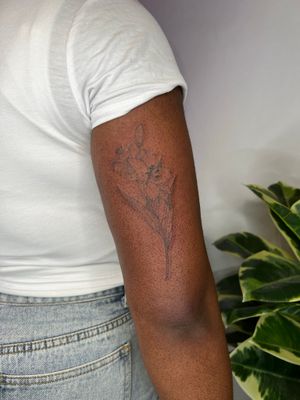 Beautiful illustrative flower tattoo on dark skin by Emma InkBaby.