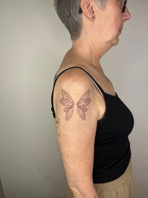 Fly high with this stunning fine line and illustrative wings tattoo, expertly crafted by Emma InkBaby. A symbol of freedom and grace.