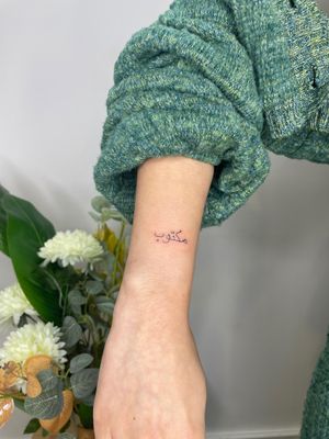 Get a small lettering tattoo of 'maktub' in Arabic script by the talented artist Emma InkBaby. Embrace the power of destiny with this stunning design.