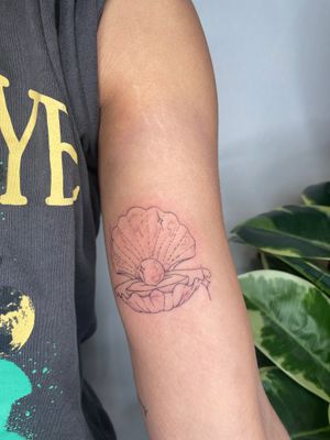 Experience the beauty of the ocean with this fine line, illustrative tattoo by Emma InkBaby. The intricate detail of the seashell and pearl will leave you in awe.