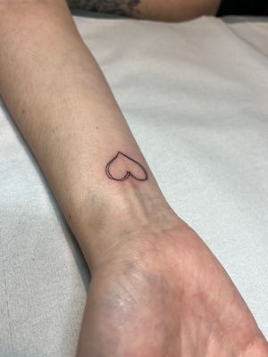 Get a delicate fine line heart tattoo by the talented artist Emma InkBaby for a timeless and elegant look.