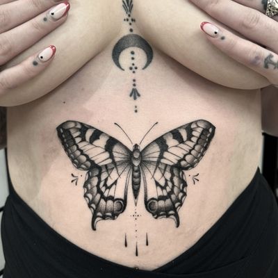Elegant blackwork illustrative butterfly tattoo by Sam Waiting, capturing the beauty of nature in ink.