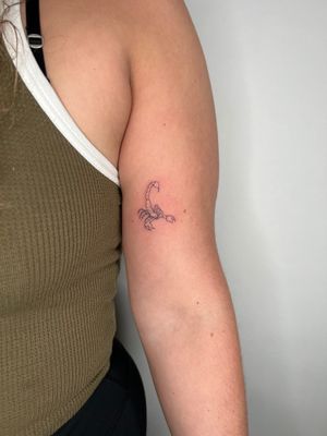 Get a stunning illustrative fine line scorpion tattoo from the talented artist Emma InkBaby. Bring your inner strength to life with this unique design.
