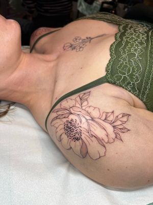 Beautiful fine line flower tattoo by Emma InkBaby, featuring a detailed illustrative floral design.