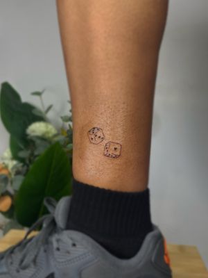Beautiful fine line dice tattoo design by artist Emma InkBaby, perfect for any gambling enthusiast.