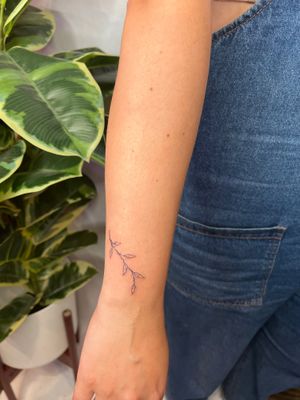 Adorn your skin with a delicate and intricate fine line tattoo of a vine branch, brought to life by the talented artist Emma InkBaby.
