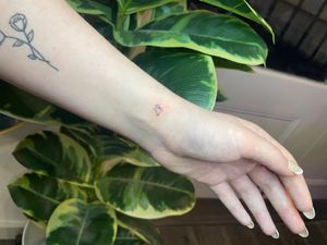 Get a stunning fine line tattoo with small lettering by the talented artist Emma InkBaby. Perfect for those looking for a subtle and elegant tattoo design.