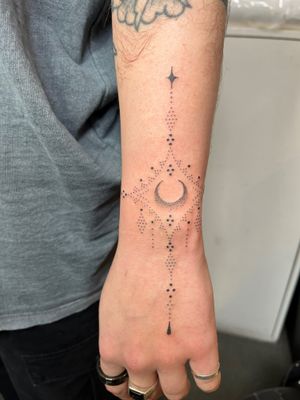 Adorn your skin with a stunning moon and ornamental pattern hand-poked tattoo by Indigo Forever Tattoos, showcasing intricate dotwork details.