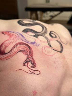 Get a striking illustrative snake tattoo in vibrant red ink by Saka Tattoo for a fierce and unique look.