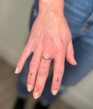 Elegant hand poked finger tattoo design by Marketa.handpoke, featuring intricate ornamental details.