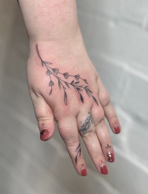 Beautiful and delicate hand-poked flower and vine design created with fine lines and intricate dotwork by the talented artist Marketa.handpoke.