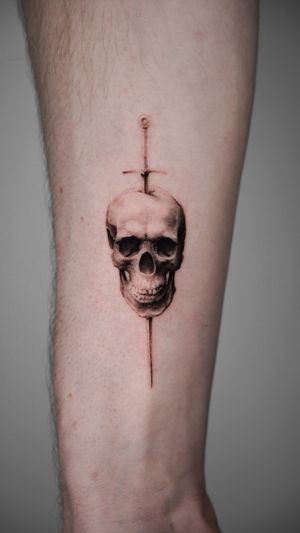 Get inked by Viola with this stunning black and gray tattoo featuring a detailed skull and sword design. Perfect for fans of micro realism art!