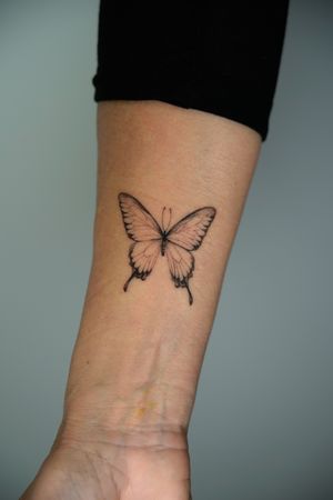 Adorn your skin with a delicate black and gray butterfly tattoo by the talented artist Viola. Embrace the beauty of nature in exquisite detail.