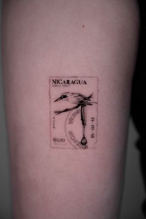 Illustrative black and gray tattoo of a Nicaraguan post stamp, beautifully done by Viola