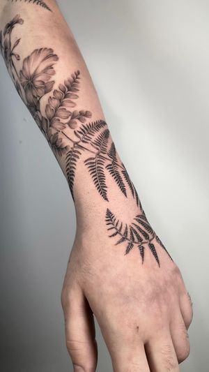 Get a beautiful black and gray illustrative tattoo of a detailed fern plant, expertly executed by the talented artist Sam.
